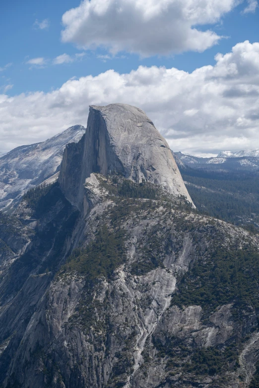 a large rock in the mountains surrounded by trees