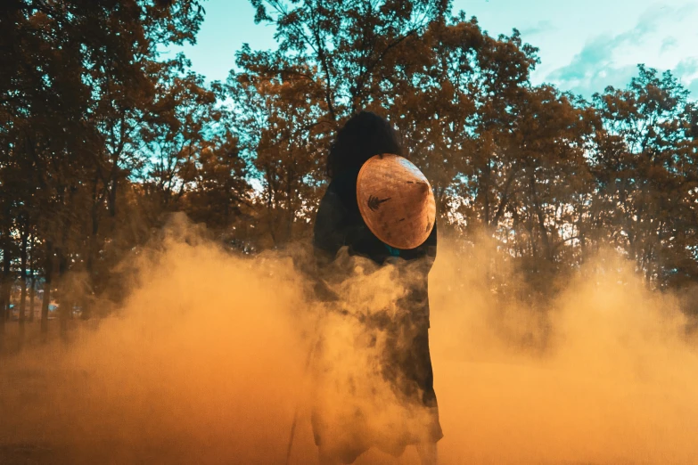 a man in a hat stands over some dust