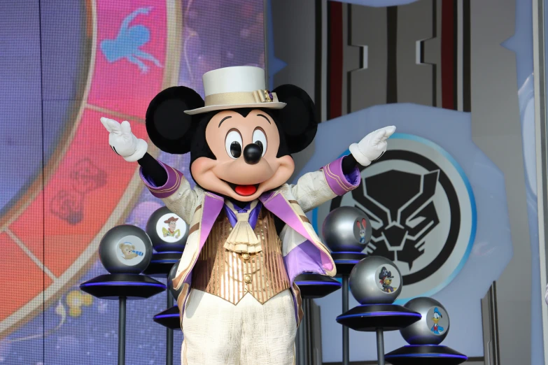 a mickey mouse in fancy clothing stands next to two silver vases