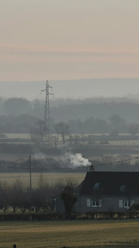 smoke comes out of a house, near the farm