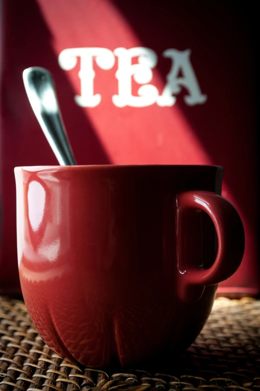 two red mugs and two spoons sit side by side