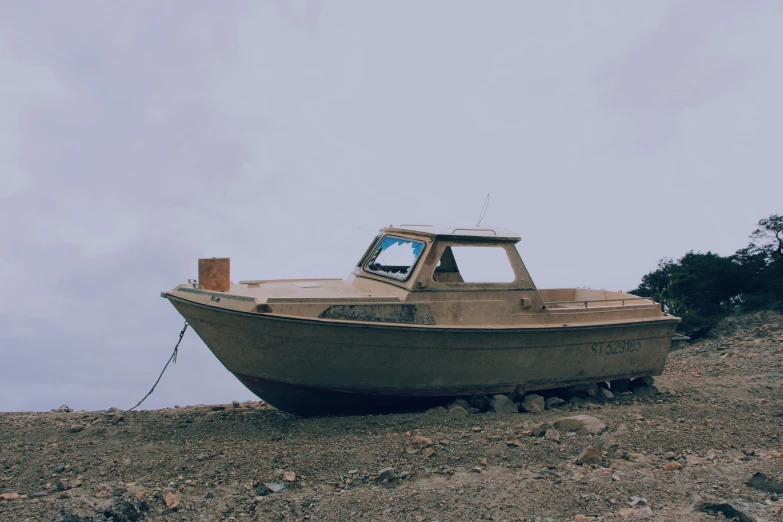 a dirty boat is sitting on the ground