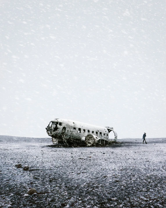 a black and white pograph of an old plane with snow falling on it