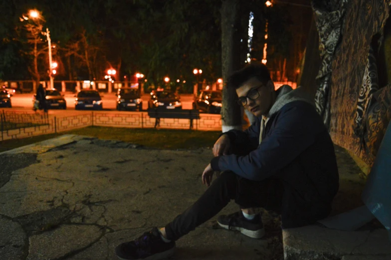 a young man sitting on concrete bench in the city