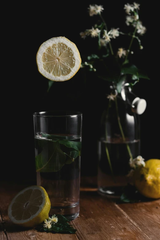 there is lemons, flowers, and water on the table