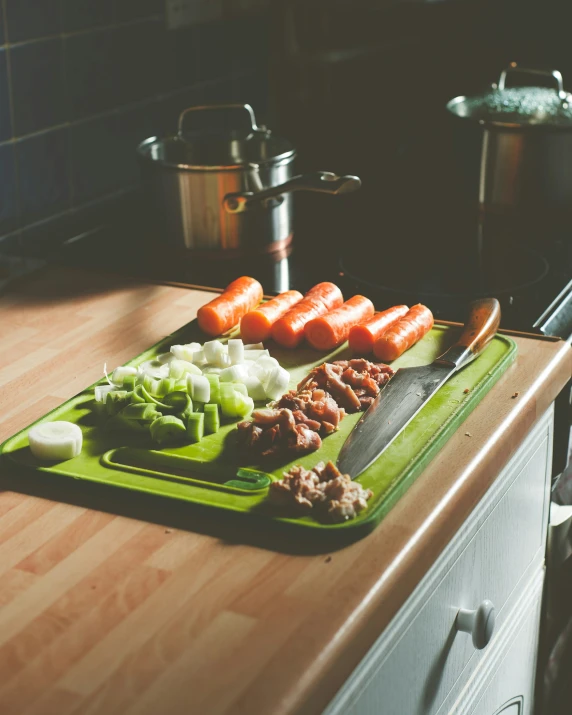 a  board with raw meat, veggies, and tomatoes