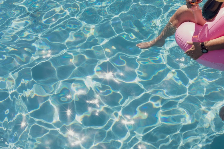 an older man and young woman with inflatable floaties floats in a pool