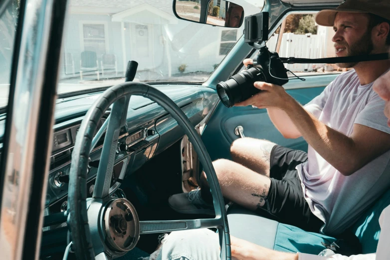 a man that is sitting in the drivers seat of a car