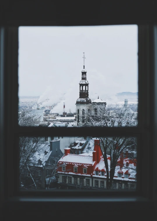 a snow covered roof tops buildings and a sky