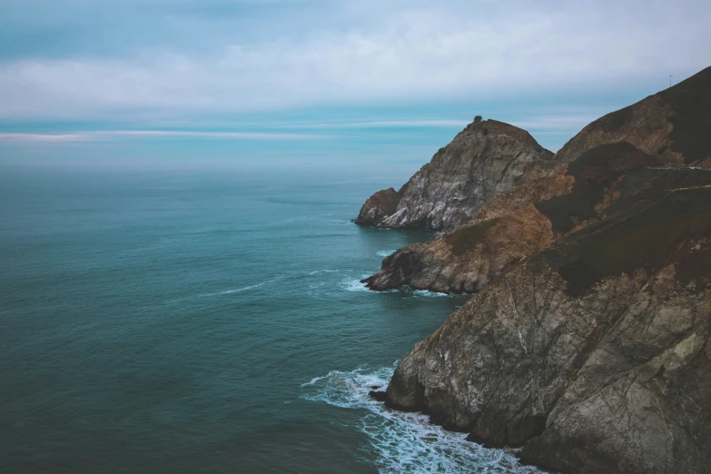 two large rocks sitting on the shore of the ocean