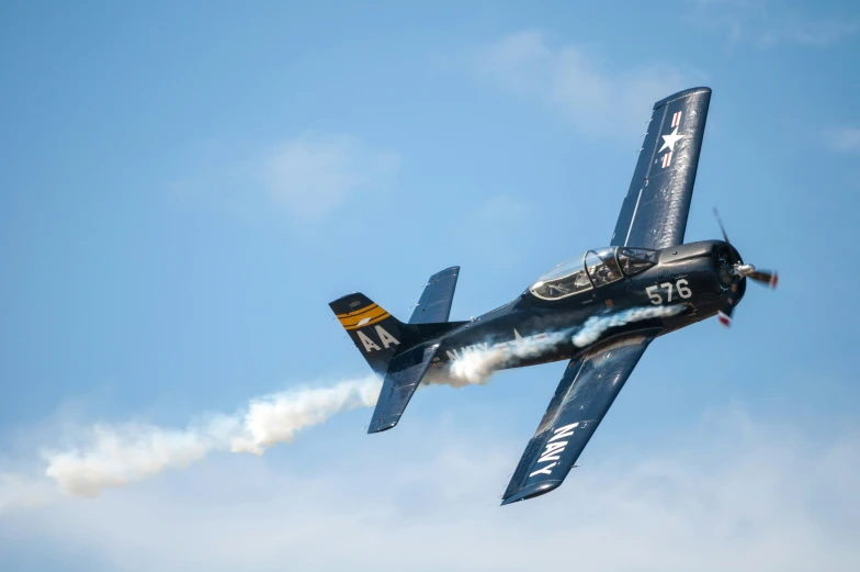 a black plane is taking off with smoke coming out of the front of it