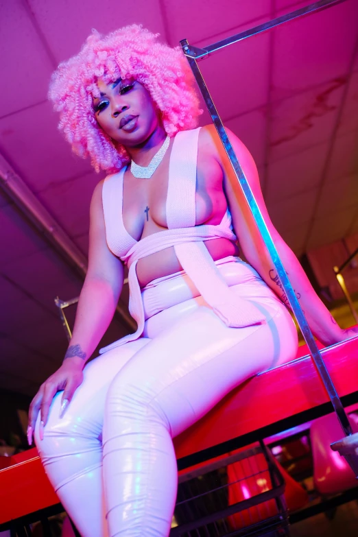 an afro girl sitting on a pink chair