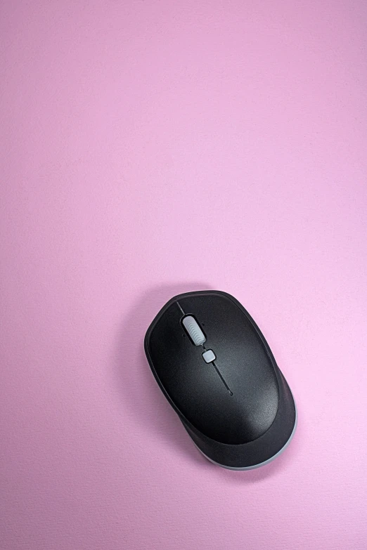 there is a small computer mouse on the pink surface