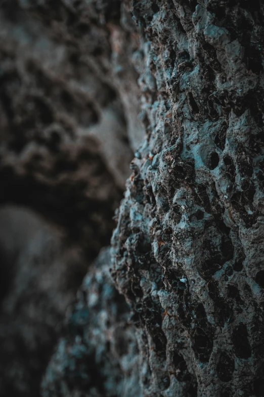 a rock face with dark, blue bubbles