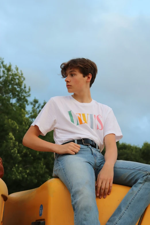 a boy is sitting on a yellow car