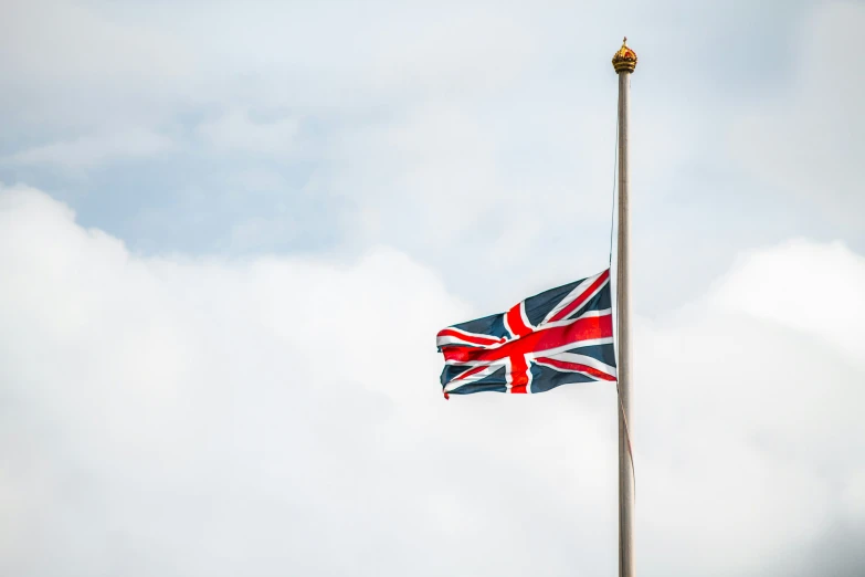 a flag flying against a blue cloudy sky