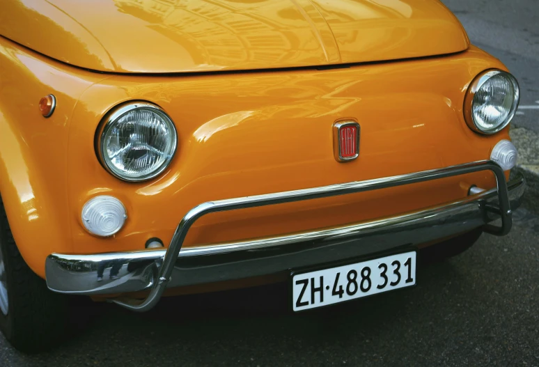 an orange car parked next to a road