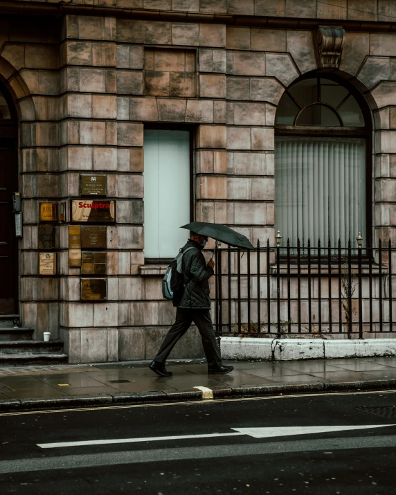 a person walking on a sidewalk with an umbrella