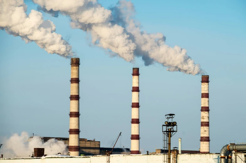 a factory with many smoke stacks sticking out of it's sides