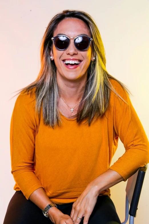 a woman wearing sunglasses is sitting in a chair