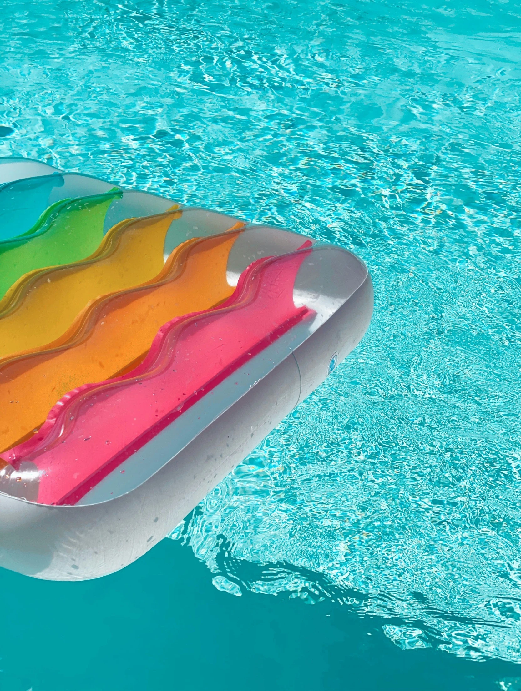 a large inflatable floating rainbow color pool