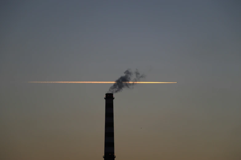 a plane that is flying in the sky and emitting smoke