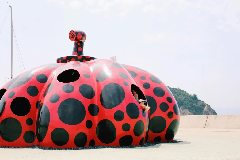 an art piece, depicting the shape and form of a huge red polka dotted building