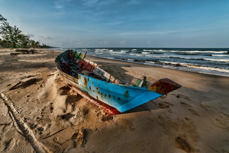 a boat sitting in the sand on the beach