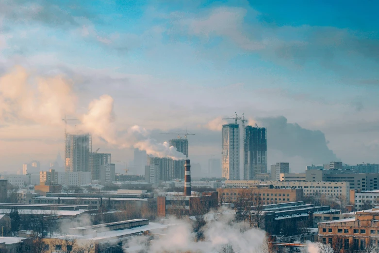 smoke coming from pipes in the cityscape with tall buildings