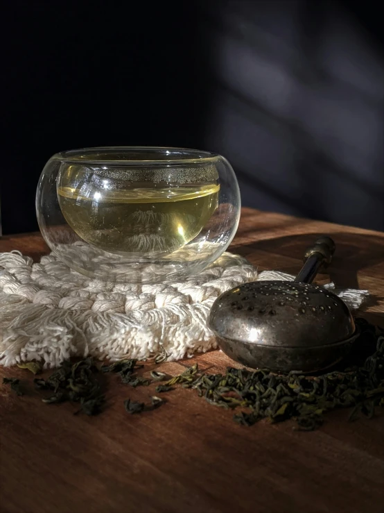 an item placed on the table near a glass bowl and a teapot