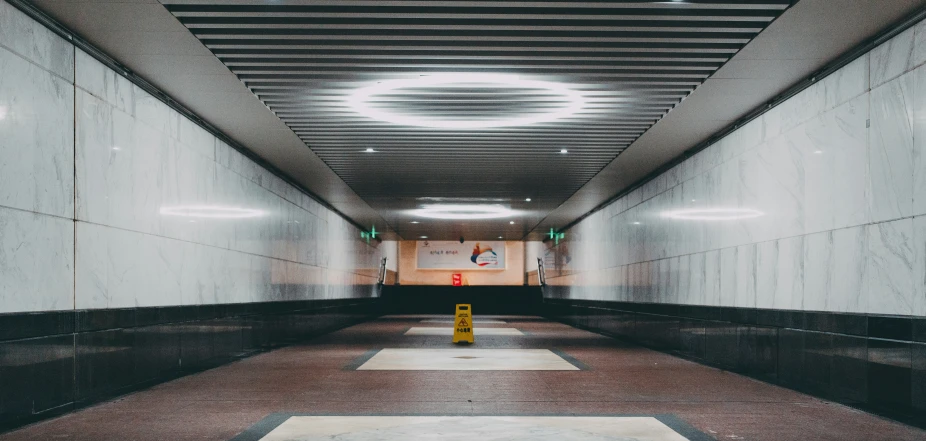 a long hallway is lined with walls and floor tiles