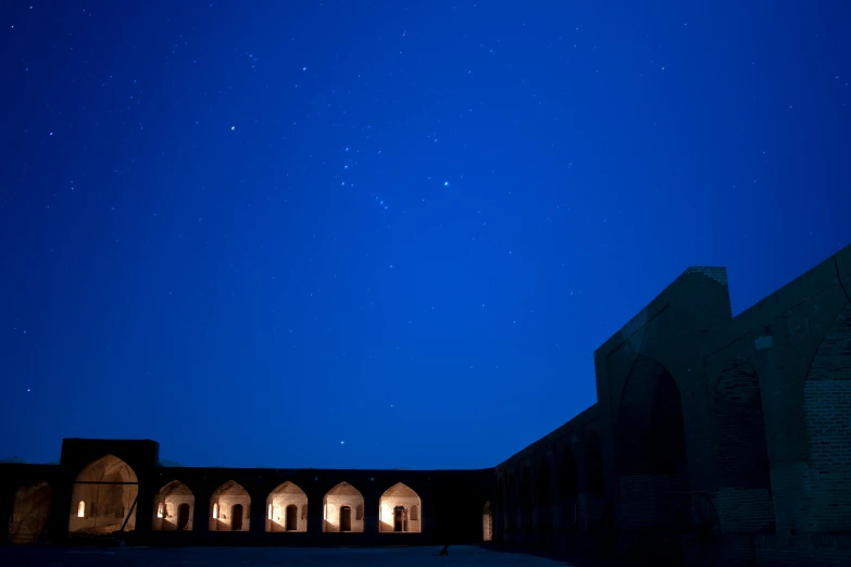 the night sky in a large building with arches on each side
