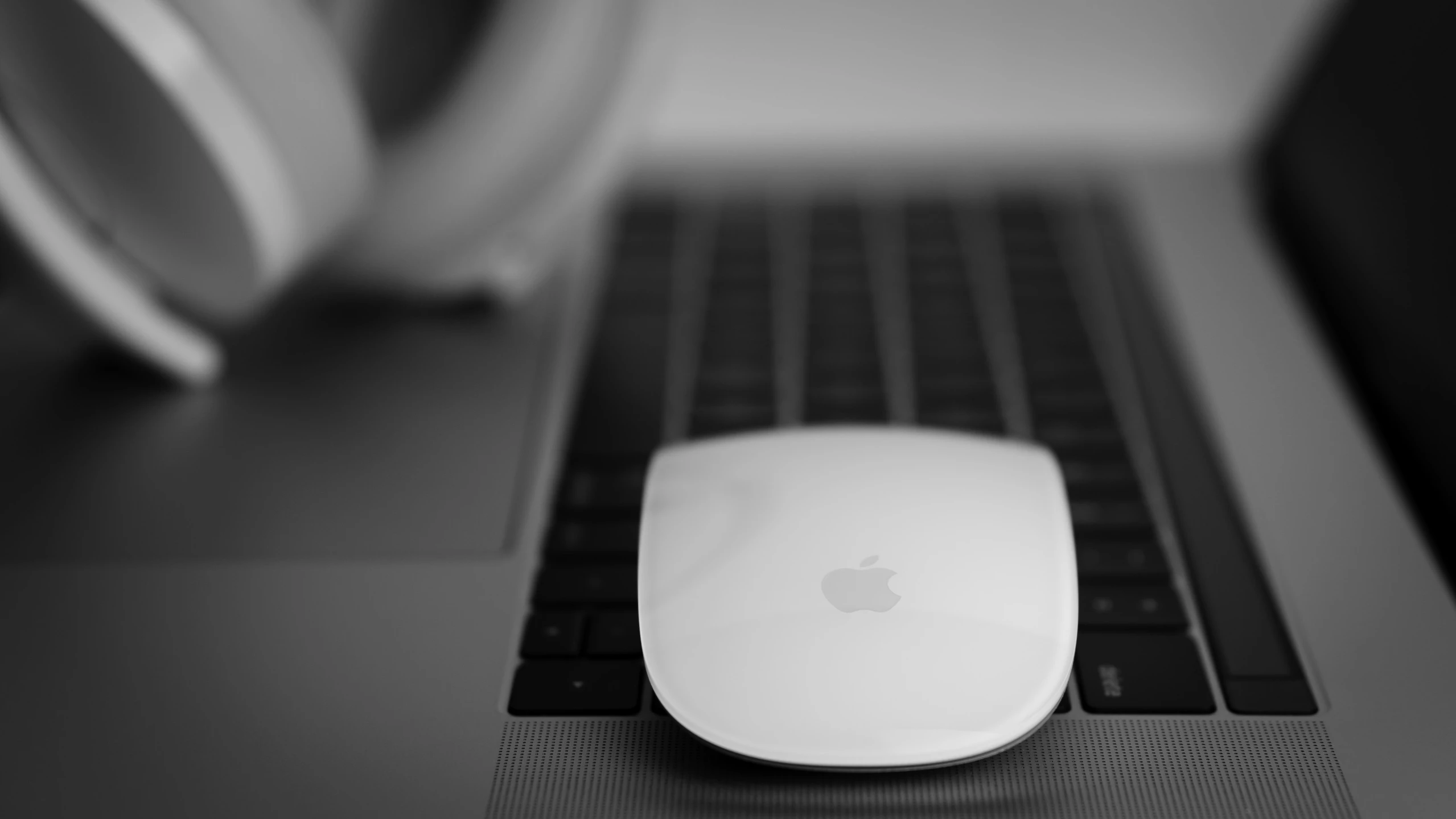 an apple mouse sitting on top of a laptop keyboard