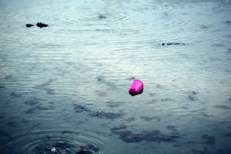 a pink umbrella in the middle of the water