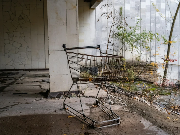 an old abandoned shopping cart sitting in the middle of a concrete yard
