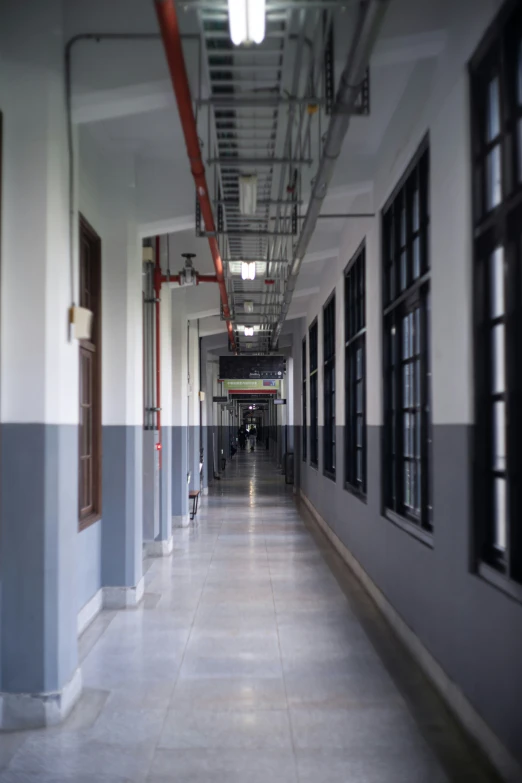 a long hallway with windows and a wall with a light