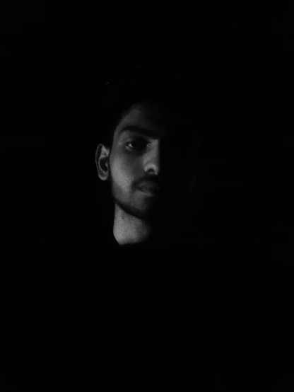 a man's face in a dark room