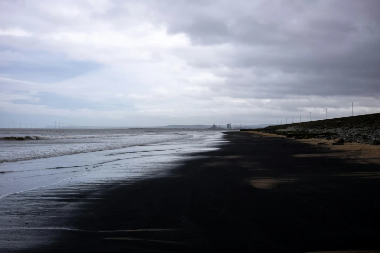 black sand beach with gray clouds and water