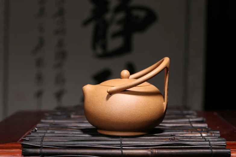 a teapot sitting on top of a bamboo mat