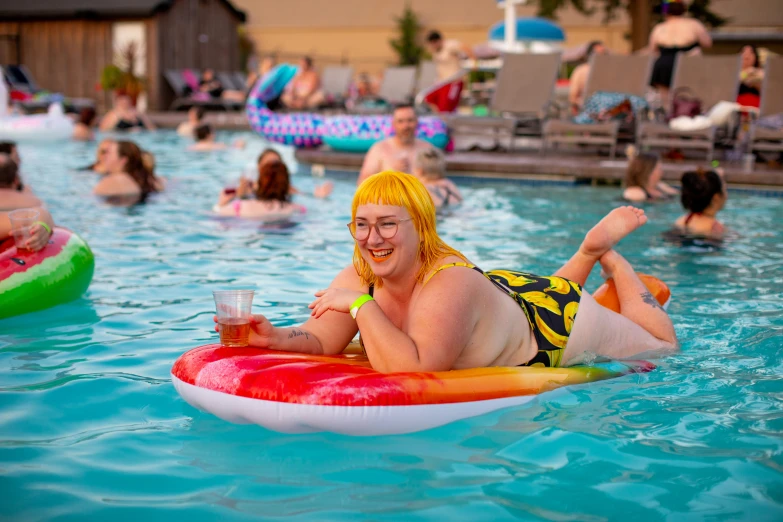 woman laying on top of a red and white raft in the pool