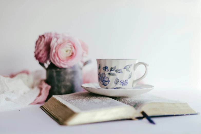 coffee cup with saucer and book on the table