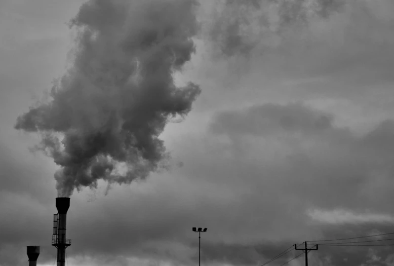 a black and white po of a factory with smoke coming out of it