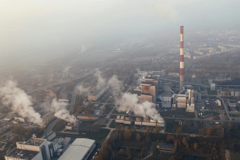 industrial buildings and smoke stacks are seen from an aerial view