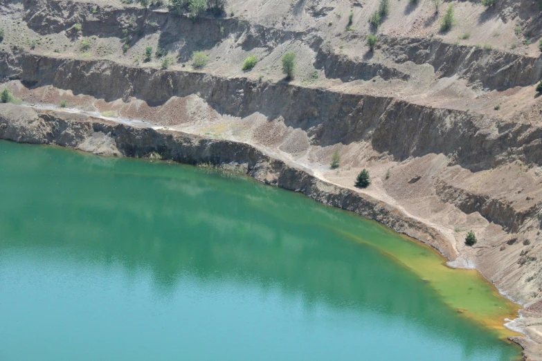 a large blue lake surrounded by a cliff