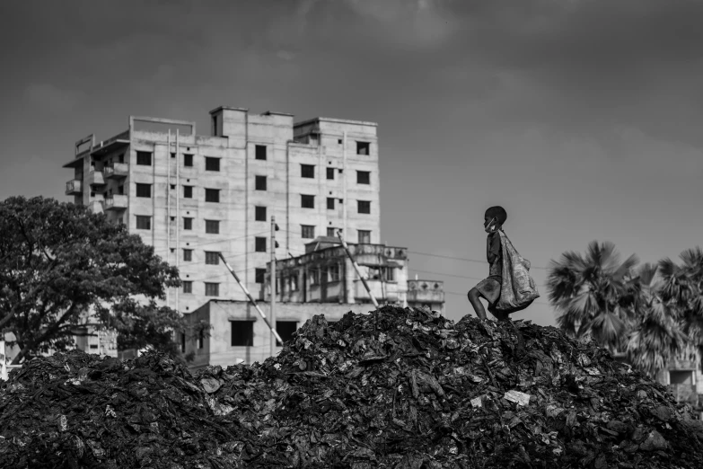 a person standing on a large pile of plants in front of a building