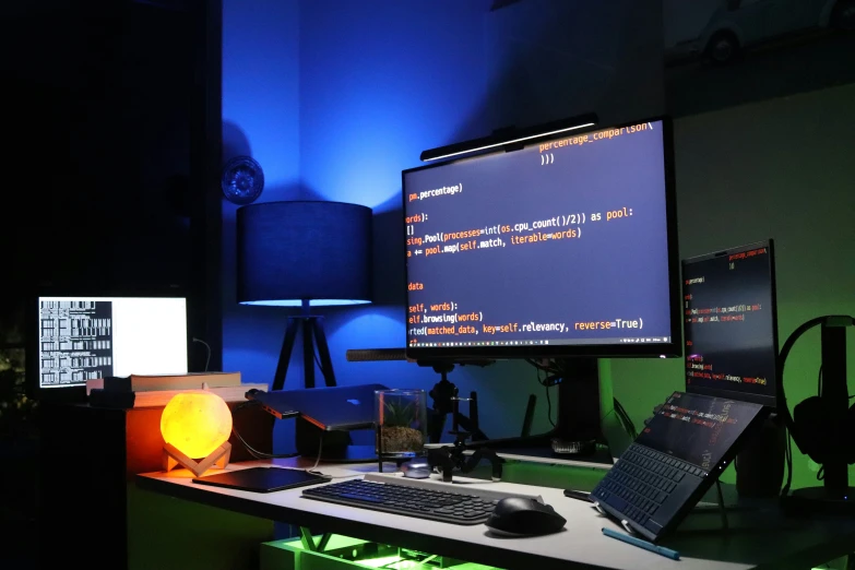 a desk with a computer monitor and a keyboard, mouse and a laptop on it