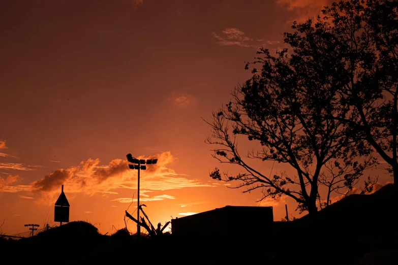 the sun is setting on a building with a large antenna in front