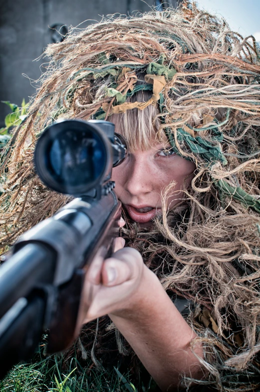 a woman with long blonde hair holding a rifle