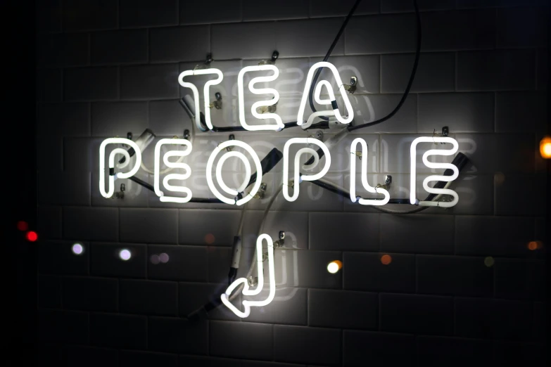 illuminated neon sign for tea people in a dark room