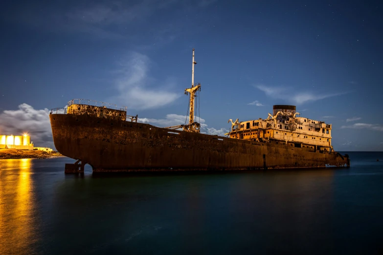 a very large ship sitting on a dry dock at night